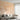 Peach mural wallpaper with cranes, mountains, and florals enhances a sunlit modern living room with beige sectional and round table.