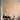 Peach wallpaper mural with white cranes, slender trees, butterflies, and hills behind a modern wooden dining table and chairs.