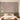 Serene bedroom with green upholstered bed, pink and tan pillows, nature-themed wallpaper mural, and dried branches on bedside tables.