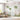 Soft pastel mural wallpaper with whimsical trees, birds, and butterflies in a sunlit living room with white sofa and round table.