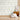 Animal-themed wallpaper with soft forest creatures in muted tones, light wooden floors, plush animal toys, framed prints, and a low wood cabinet.