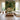 A modern living room with light wood floors and a bold, forest-themed wallpaper featuring animals and a small building as the focal point.