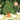 Wallpaper design with cows grazing near a tree heavy with fruit, amid lush greenery and domed pavilions, in a miniature art style.