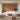 White sectional sofas frame a modern living room with floor-to-ceiling windows and a brown wallpaper featuring tree patterns and figures.