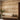 Wallpaper displays whimsical rows of pastel animal and tree motifs, complementing a light brown bench and lush potted plants in a serene room.
