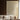 Beige wall mural showcases sweeping white abstract lines, complementing a white sofa and wooden accents in a sunlit living room.