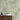 White floral outlines pattern an olive green wallpaper, paired with a dark wood sideboard, black bird sculpture, and ceramic accents.