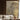 Abstract gold and brown leaf-patterned mural decorates the wall behind a beige sofa with wooden accents, beside a large curtained window.
