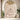 Abstract mural of a pregnant silhouette with flowing brown and white stripes spans a beige arched wall, accented by lush green plants and tall windows.