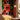 Bold, colorful abstract mural with geometric shapes adds a lively touch above mustard-yellow booth seating and warm wood paneling.