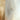 Wallpaper with layered vertical brushstrokes in soft beige, tan, gray, and white, accented by faint horizontal textures for a subtle, modern look.