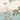 Vivid hummingbird hovers over misty sea and sailing ships, framed by lush green branches and red berries on soft, cloudy wallpaper.