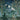 White cranes glide above tall green trees on a painterly wallpaper, lush foliage below under a moody, clouded night sky.