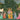 Krishna and Radha stand by a water‚Äôs edge, playing flute among gopis in vibrant dress, cows, wildlife, and lush green wallpaper scenery.
