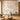 Living room with a round wood coffee table, chair, sideboard, and a mural wallpaper of flowering trees, birds, and soft mountains.