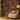 Deep red wallpaper featuring exotic trees, lush green foliage, and peacocks, styled in a room with a cream armchair and a glowing floor lamp.