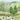 Pastoral wallpaper features grazing cows on green hills, a distant windmill, clustered trees, and hay-filled wagon amid peaceful scenery.