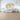 Noah‚Äôs Ark wallpaper with charming animals, sun, clouds, and ocean waves brightens a nursery wall above a white crib and plush toys.
