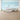 Ocean-themed mural wallpaper featuring playful cartoon narwhals, whales, and fish in soft blues and pastels behind a white crib.