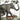 Playful jungle-themed wallpaper features an elephant with a wild dog and bird riding its back, surrounded by a tiger, monkey, ostrich and lush tropical foliage.