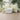 Forest-themed nursery wall mural with illustrated deer, birds, badger, and rabbits beneath tall trees and grass; white crib in front.