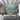 Underwater coral reef wall mural with vibrant fish and ocean plants adds color to a modern living room with a gray sofa and hanging chair.