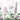 Soft purple and green wildflowers and leafy botanicals form an elegant pattern on a pale background with delicate floral outlines, perfect for accent walls.