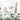 Delicate wildflowers in soft purple and green hues form a subtle, elegant pattern on a white backdrop with faint botanical sketches.
