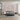 Soft pink accent wall adorned with a delicate floral and bird mural in a modern bedroom, complemented by minimalist gray furnishings and gentle natural light filtering through sheer curtains.