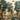 Elegant wallpaper pattern shows a verdant garden scene with statues, fountains, birds in flight, and figures among trees and flowers.