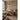 Beige mural featuring abstract forest brushstrokes on a bedroom wall, complemented by layered neutral bedding, wood furniture, and a glowing lamp.