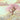 Whimsical wall mural featuring a pointed fantasy cottage nestled in cherry blossoms above golden sunset clouds, perfect for an ethereal room.