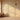 Sunlit room with arch-patterned wallpaper, floral and plant motifs, wicker and ceramic vases on wood floor, woven pendant overhead.